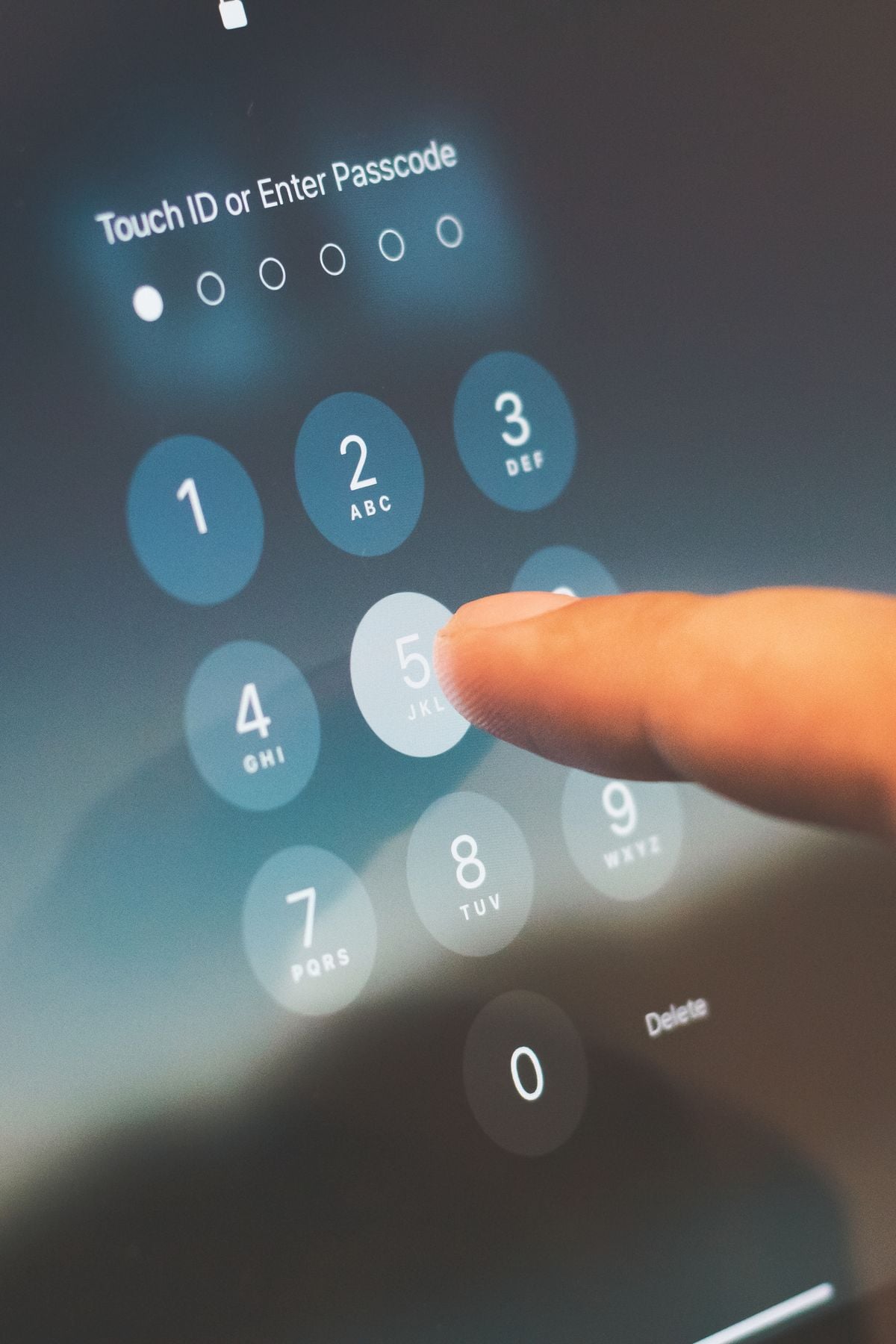 Finger entering a device passcode, representing secure passwordless authentication