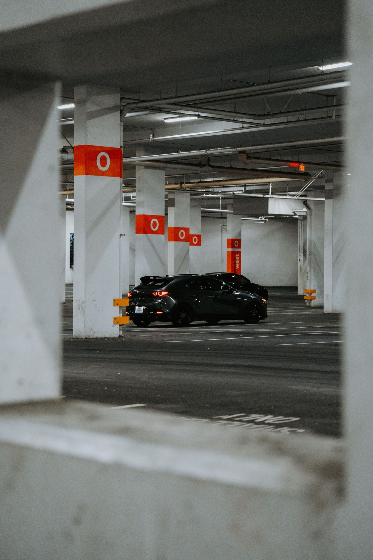 Dark car in a monitored parking garage, representing automated theft detection